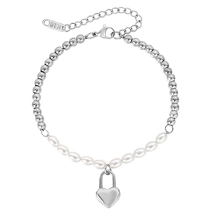 Chic silver beaded bracelet with white pearls and polished heart locket charm on white surface