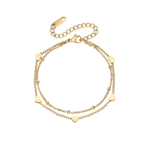 Detail of double-layer stainless steel heart charm bracelet in polished 18K gold finish