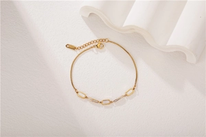 Dettaglio bracciale oro rosa con inserti in conchiglia e zirconi su sfondo in pietra