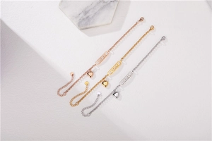 Detailed view of rose gold, gold and silver MOM heart charm bracelets with lobster clasp