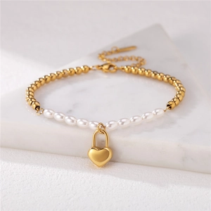 Minimalist pearl and gold bead bracelet with a 3D heart lock pendant on marble