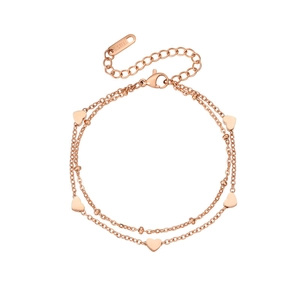 Detail of rose gold double-layer stainless steel bracelet with heart pendants