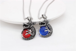 Detail of vintage dragon claw pendants holding red and blue beads on metal chains