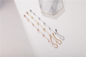 Detailed view of gold, silver, and rose gold minimalist bead bracelets with lobster clasps