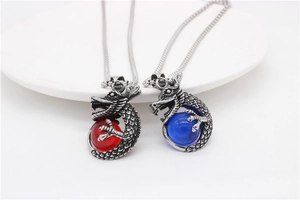 Detailed view of silver dragon pendants holding red and blue crystal beads on metal chains