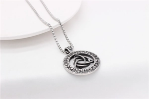Macro detail of vintage Viking rune pendant with Celtic knot on a white textured background