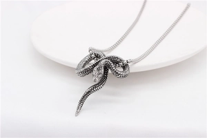 Detailed macro view of the intricate snake scale texture on a vintage silver pendant