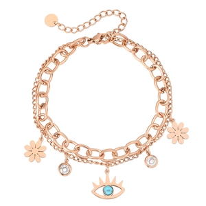 Bracelet à maillons cubains en or rose avec pendentifs œil et marguerite sur fond blanc