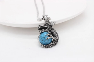 Macro detail of retro dragon pendant with blue stone and intricate silver scales