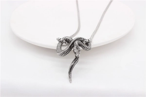 Macro shot of retro silver snake pendant showing detailed scales and 3D texture