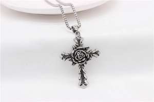 Close-up of retro rose cross pendant in blackened steel on a square pearl chain
