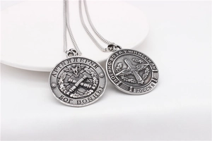 Detail of vintage steel necklace featuring Russian military emblem and artillery reliefs