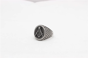 Detailed view of vintage silver Freemason signet ring with Masonic G symbol and brick texture