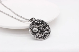 Vue macro détaillée d'un pendentif dragon rétro en acier inoxydable avec gravures