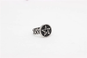 Macro detail of retro pentagram ring featuring a vintage silver-tone chain band