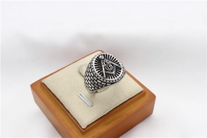 Macro detail of retro Freemasonry men's steel ring with compass symbol and brick texture