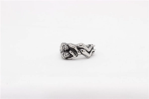 Macro detail of retro stainless steel ring showing an artistic embrace sculptural design