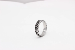 Detailed macro shot of vintage Viking Celtic knot patterns on a silver steel ring