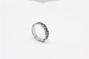 Macro detail of silver stainless steel ring featuring intricate Celtic knot engravings