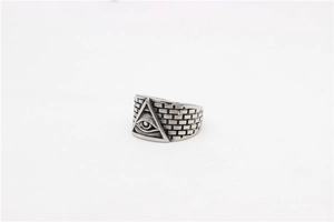 Macro detail of retro stainless steel ring featuring All-Seeing Eye and brick pattern