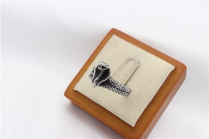 Macro shot of retro snake ring with detailed scales and head on velvet jewelry stand