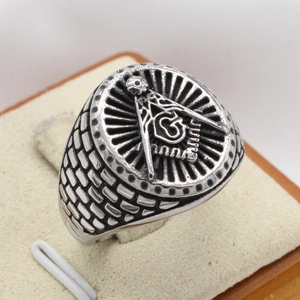 Retro stainless steel Freemason ring with G symbol and brick texture on display