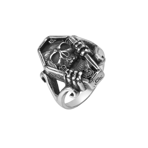 Macro detail of gothic coffin ring featuring carved skull and rose in dark titanium steel