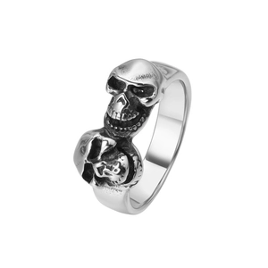Close-up of vintage steel ring featuring dual skull heads and oxidized silver finish