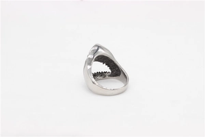 Detailed close-up of a silver shark ring with sharp teeth and polished metal finish