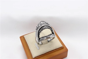 Detailed close-up of a vintage steel shark ring showing sharp teeth on a velvet stand