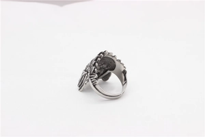 Detailed close-up of retro silver stainless steel skull ring with intricate relief textures