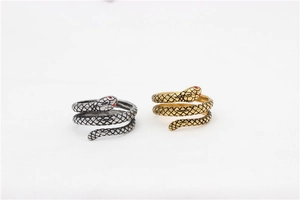 Detailed view of snake rings with red rhinestone eyes and scaly textures in gold and silver