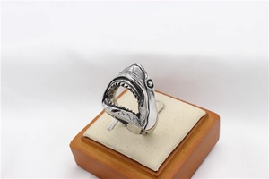 Macro detail of retro stainless steel shark head ring with vintage silver engraved finish