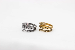 Macro shot of silver and gold snake rings featuring textured scales and red gemstone eyes
