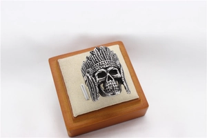 Detailed macro shot of vintage Indian chief skull ring with intricate feather carvings