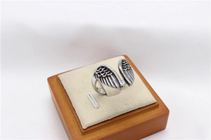 Macro detail of vintage steel angel wings ring with feathered texture and oxidized finish