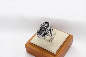 Detailed side view of punk gothic coffin ring featuring a silver skull carving