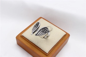 Macro detail of vintage angel wing stainless steel ring with oxidized feather texture
