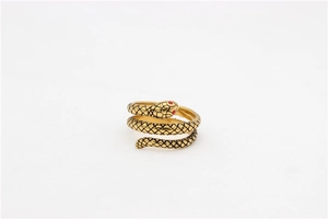 Detailed view of vintage gold snake ring with red gem eyes and black scale texture