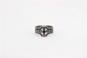 Macro detail of gothic celtic cross ring with black stone and engraved knot patterns