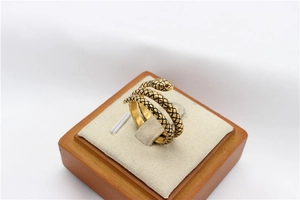 Detailed view of golden snake ring with black scale texture and ruby red gemstone eyes