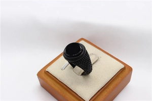 Dettaglio dell'anello vintage nero con gemma rotonda e trama a scaglie sulla fascia