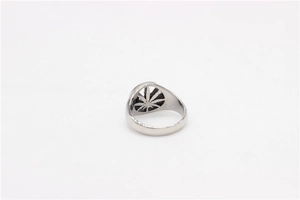 Macro detail of vintage silver steel ring featuring intricate hollowed maple leaf pattern