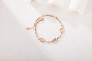 Detail of rose gold bracelet featuring a rectangular zircon stone and lobster clasp closure