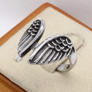 Retro angel wing titanium steel ring for men with vintage finish on jewelry stand