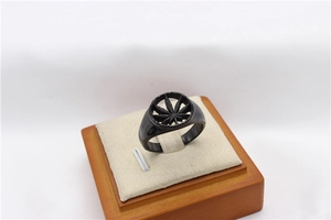 Macro view of matte black stainless steel signet ring with hollow maple leaf design