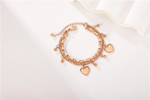Detailed view of rose gold double-layered heart charm bracelet with lobster clasp