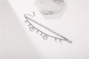 Close-up of double-layer stainless steel bracelet with white heart charms and marble decor