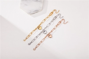 Detailed view of paperclip link bracelets in gold, silver, and rose gold with heart charms