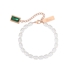 Detail of pearl bracelet with emerald green gemstone and rose gold 'Love' charm